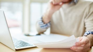 carrier-person-looking-at-report-with-laptop