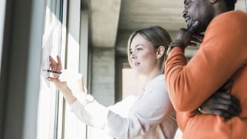 man-woman-looking-at-whiteboard
