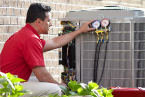 a bryant hvac contractor checks the gauges on an air conditioner