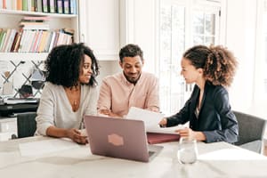 couple-reviews-paperwork-with-sales-woman-3x2