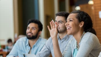 woman-raising-her-hand-to-ask-a-question-sitting-next-to-two-men