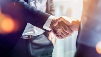 corporate men shaking hands in partnership