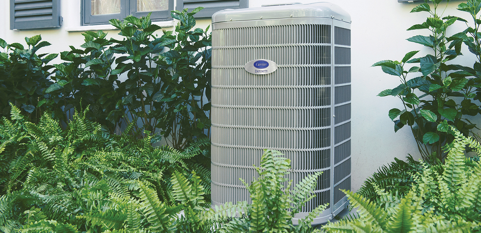 a heat pump sits outside a home after homeowner considered air conditioner vs heat pump