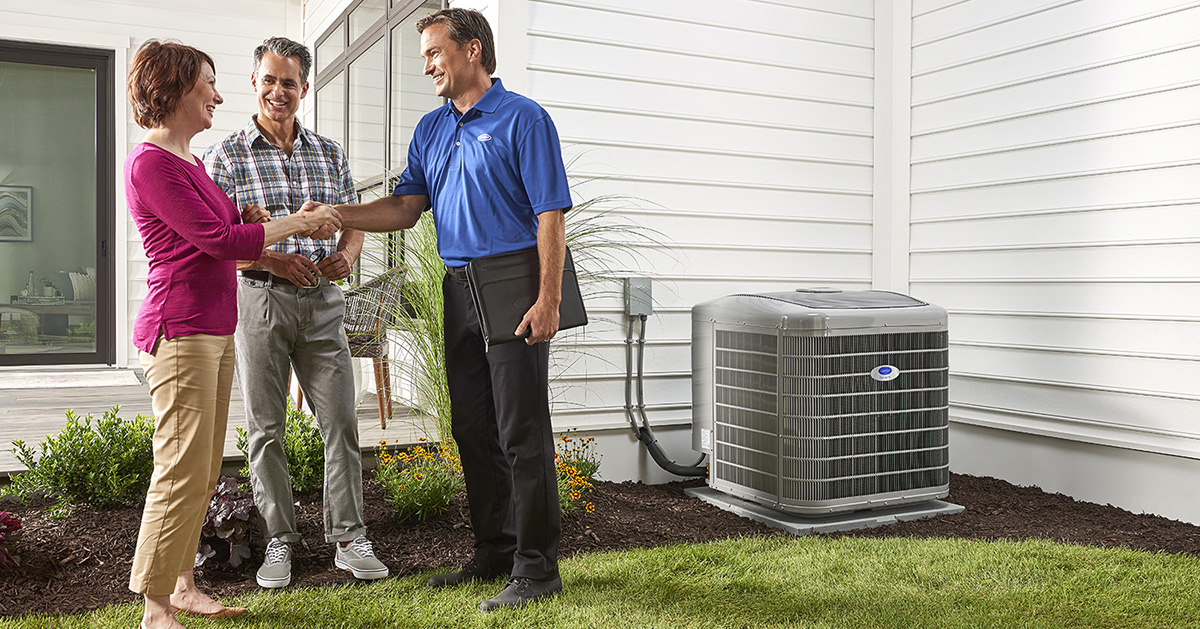 a homeowner shakes a carrier dealer’s hand after frozen air conditioner coil is fixed