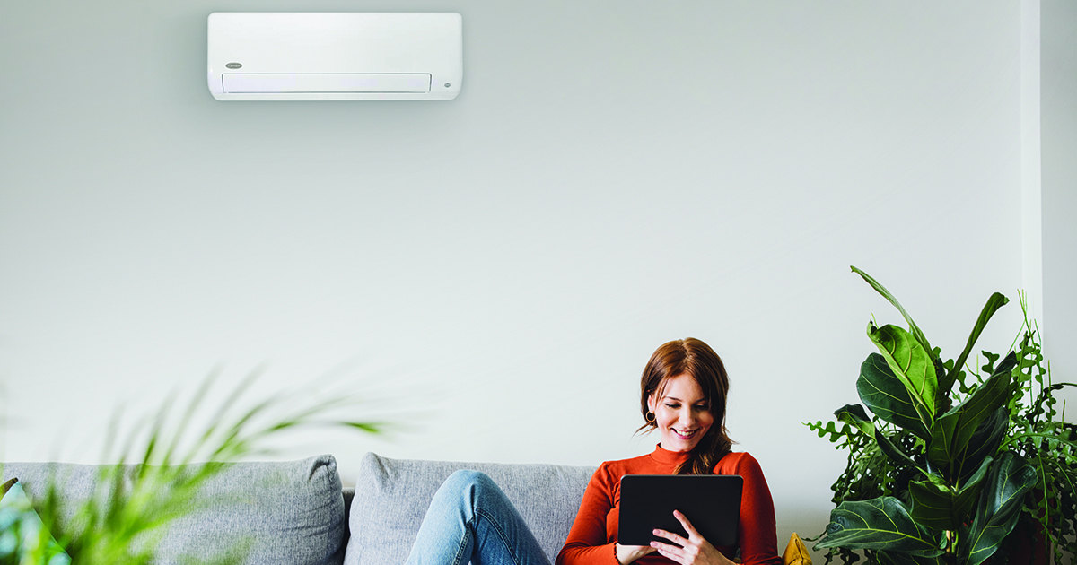 a woman enjoys the comfort of a wall mounted air conditioner, or wall mounted AC unit