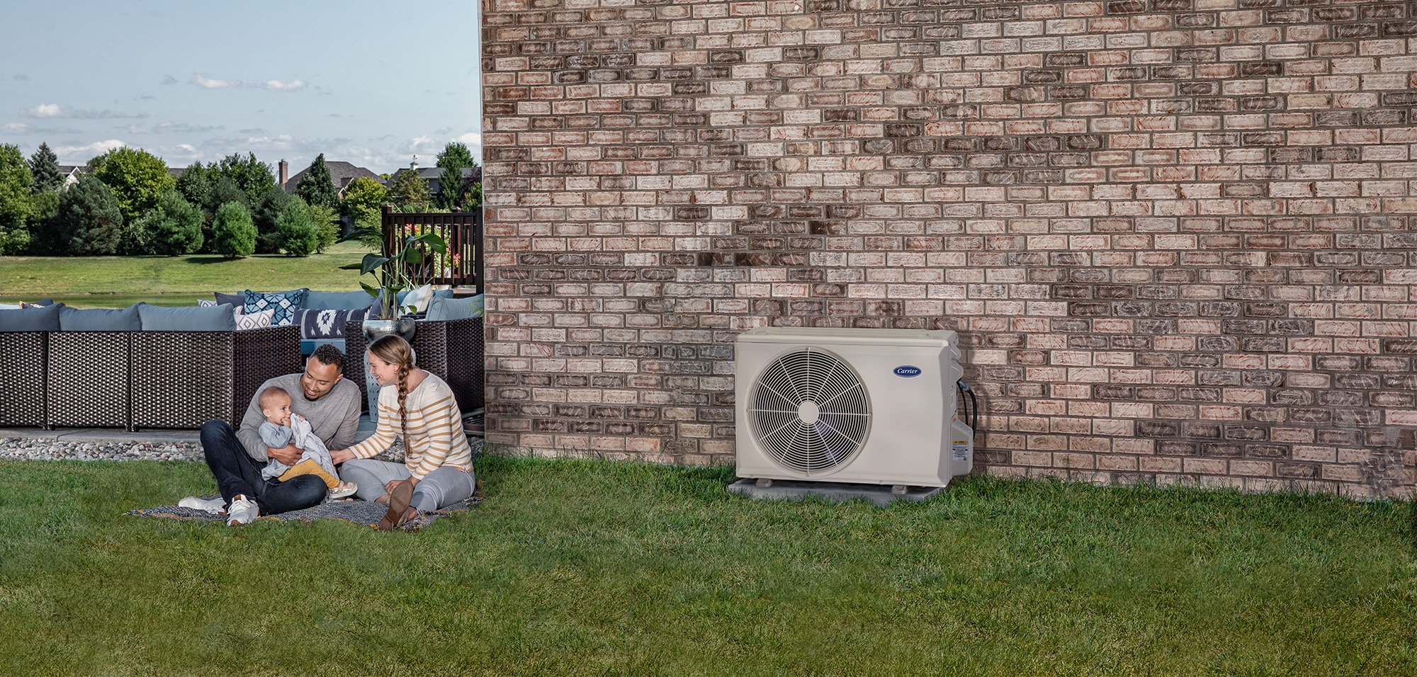 A family sits outside near their heat pump mini split