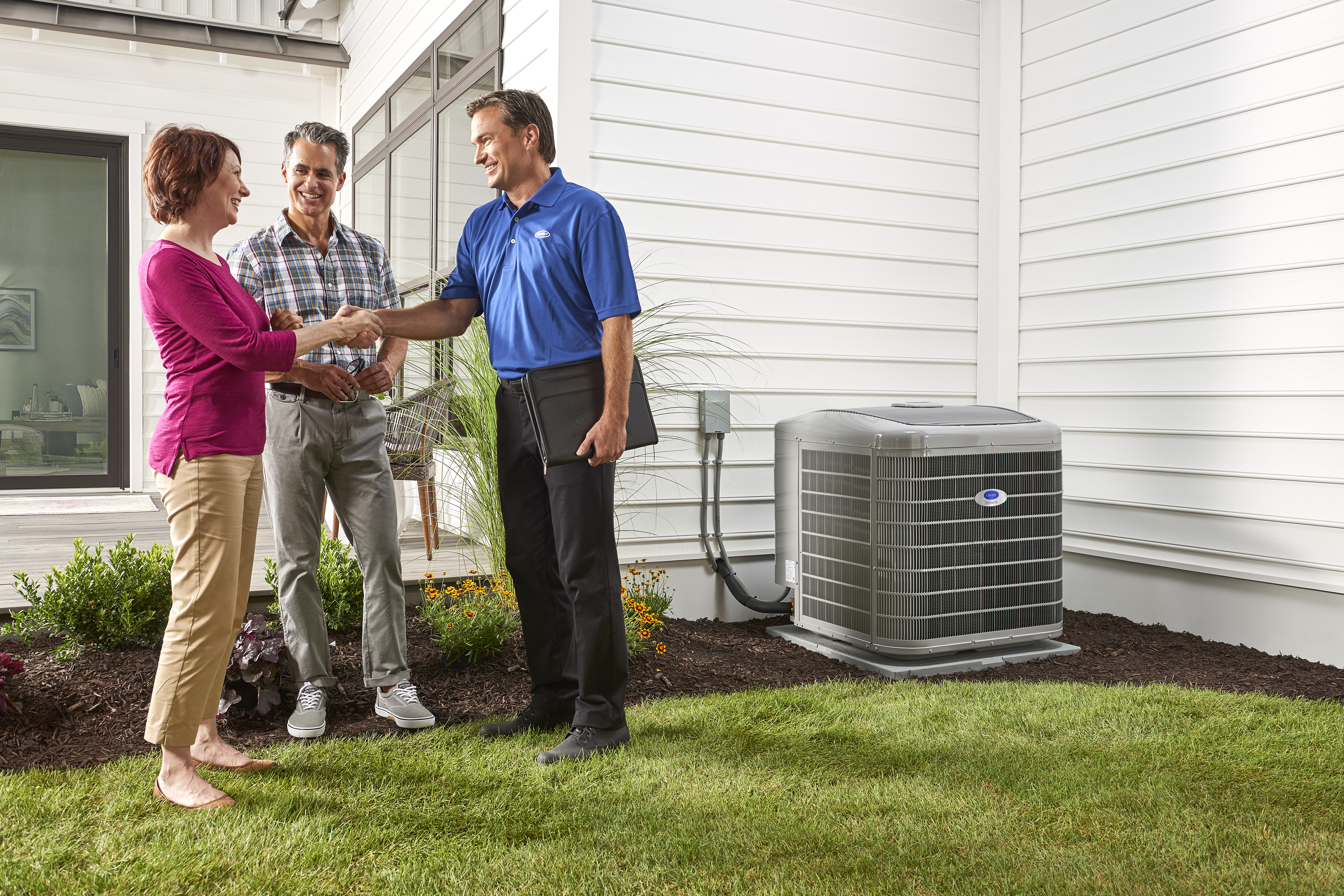 a carrier dealer shakes hands with a homeowner after air conditioner repair near me