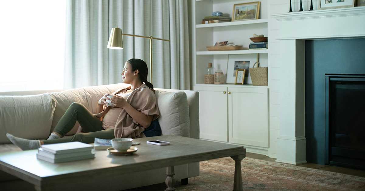 woman-sitting-on-a-couch-wondering-what-size-air-conditioner-do-I-need