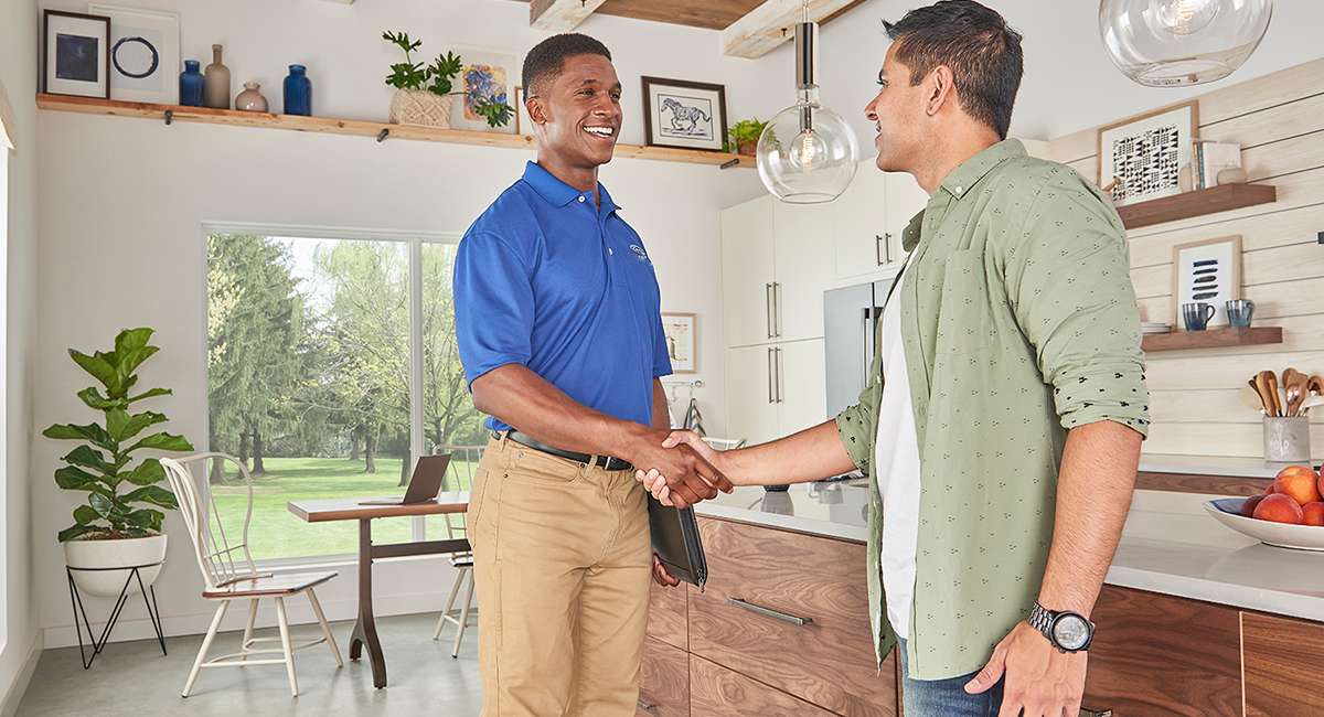 a-carrier-dealer-talks-to-a-homeowner-after-performing-furnace-installation