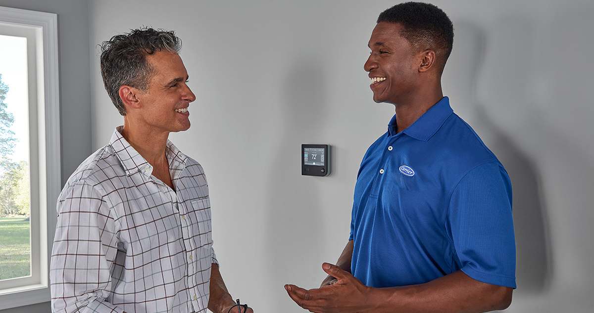 a-carrier-dealer-talks-to-a-homeowner-about-heat-pump-tax-credits
