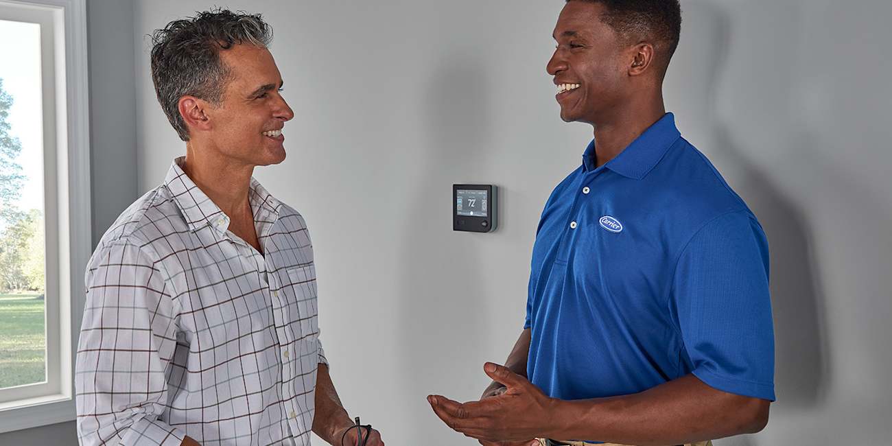 a carrier dealer discusses programmable thermostat options with a homeowner