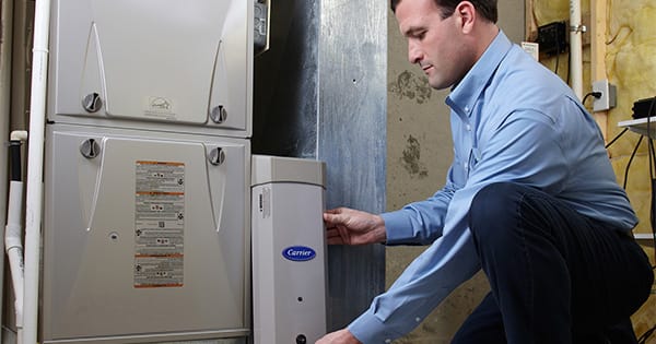 A Carrier dealer changing a filter with an MERV filter ratings of 15.