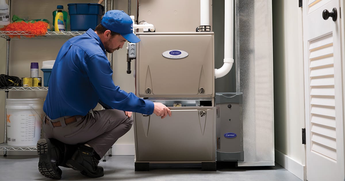 A dealer inspecting a gas furnace installed in a garage.