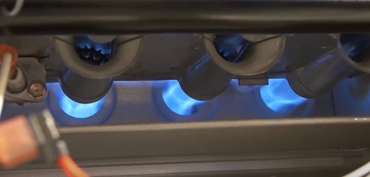 home furnace gas flame emitting from natural gas furnace burners.