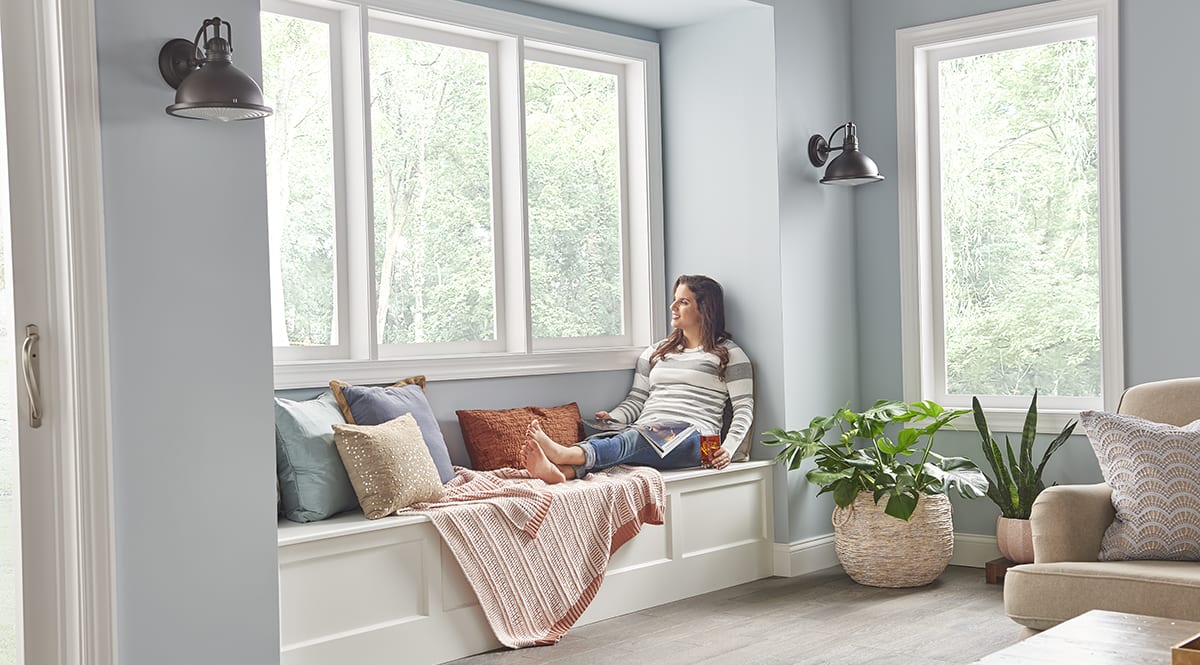 a woman relaxes in a living room with a geothermal heating and geothermal cooling system installed