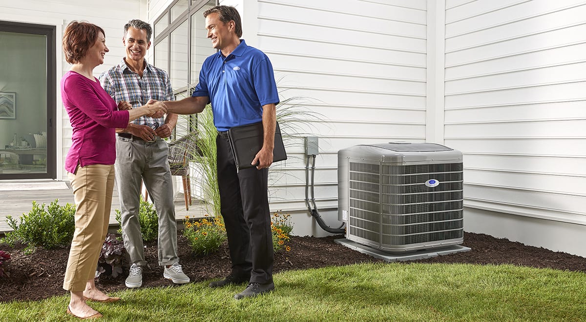a carrier dealer shakes a woman's hand after performing heat pump installation