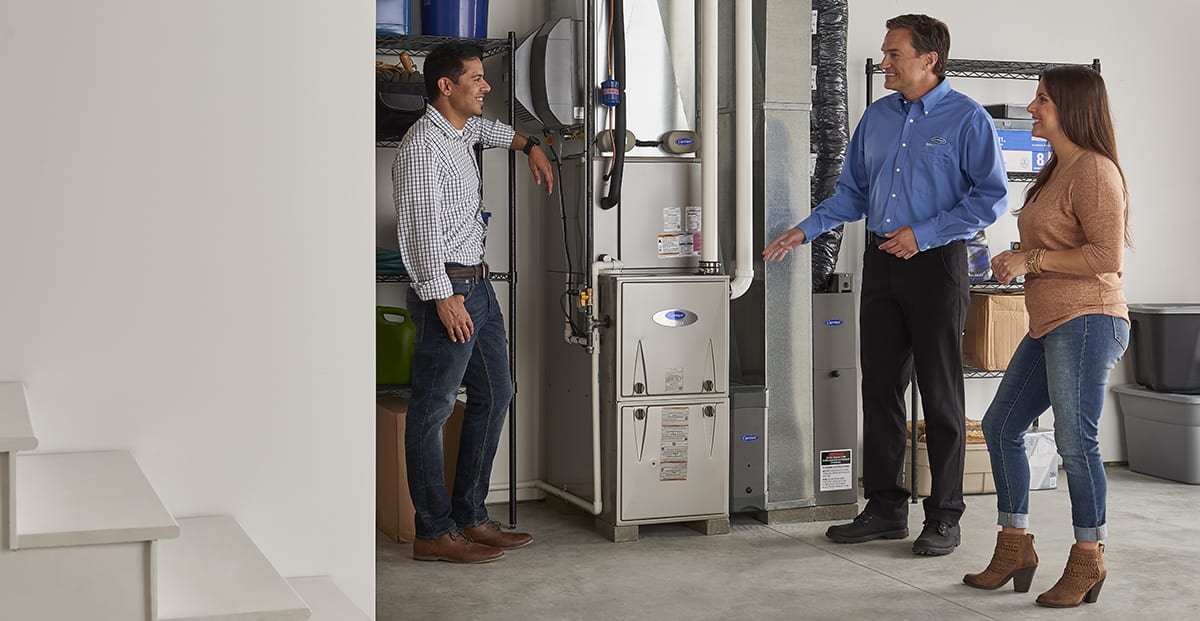 a carrier dealer discusses heating and air conditioning options with a couple