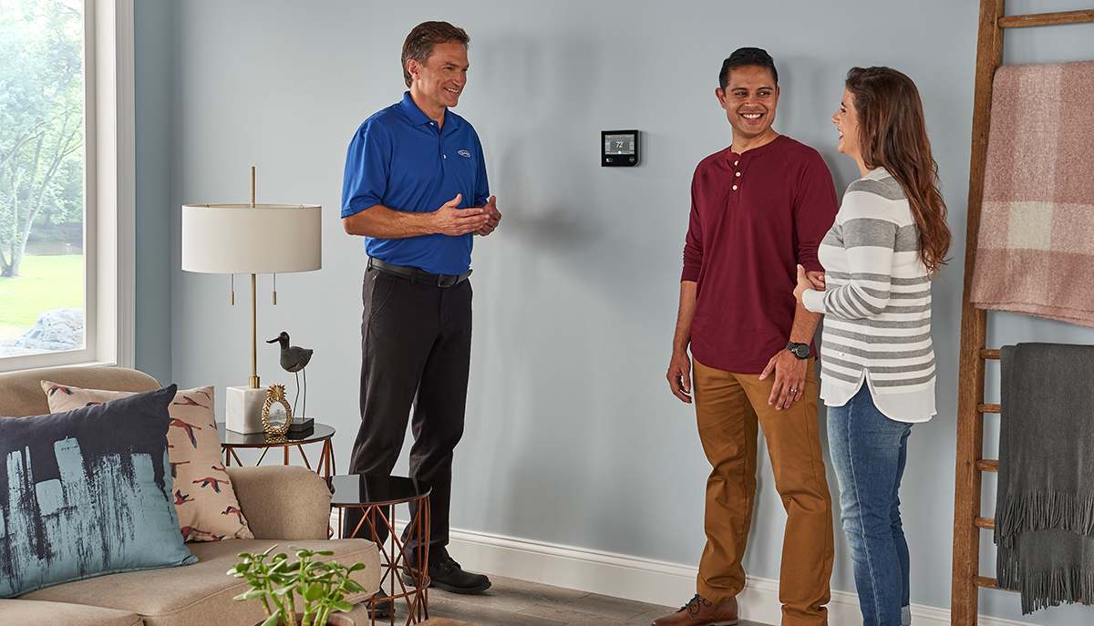 a carrier dealer discusses furnace uv light options with a couple