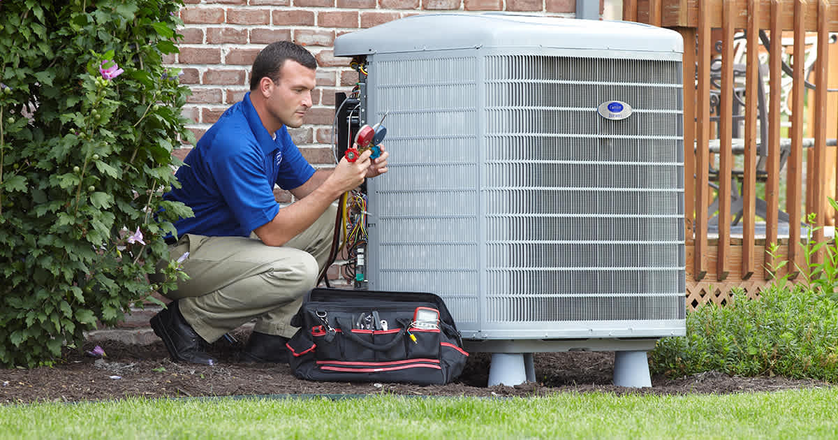 a carrier dealer inspects air conditioner blowing hot air
