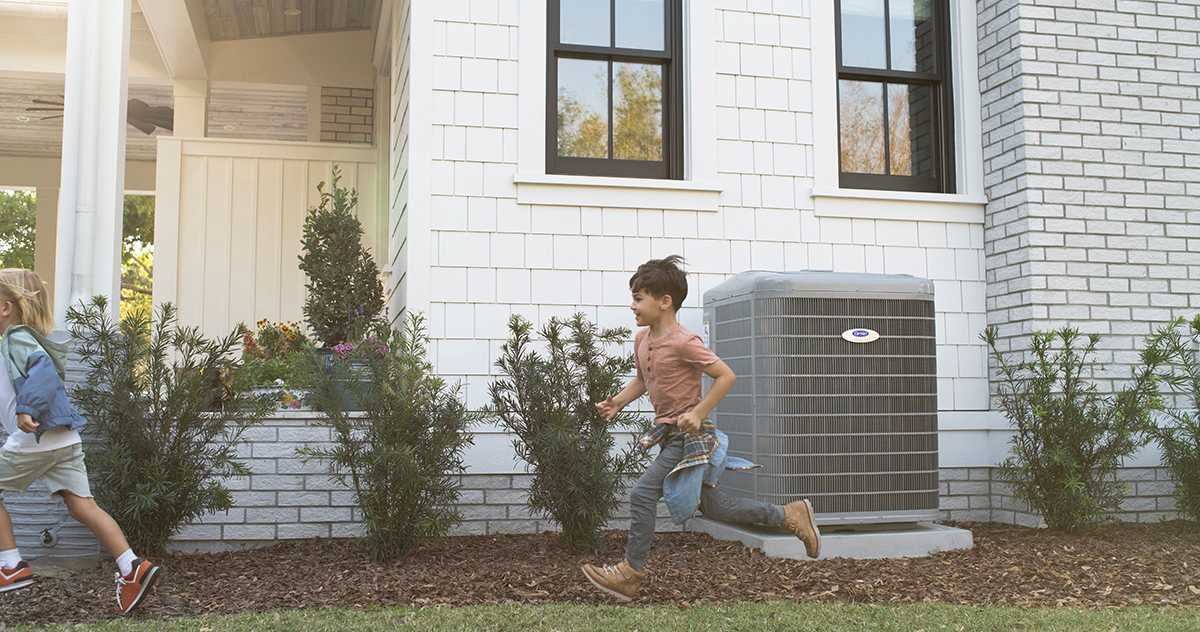 a boy run by a carrier air source heat pump