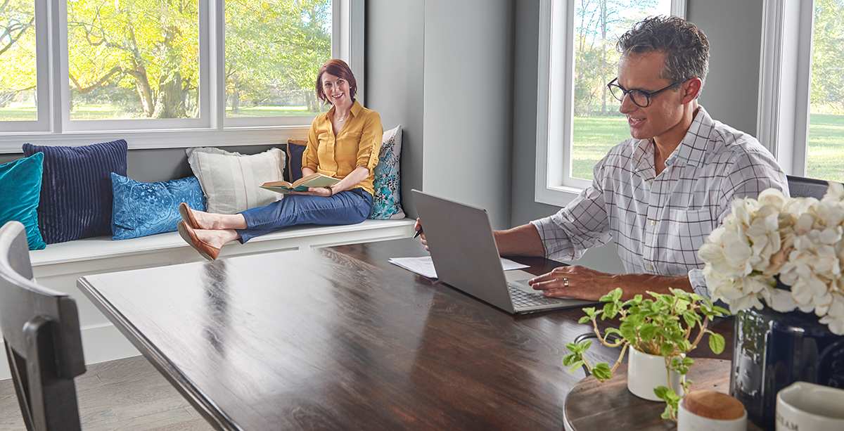 a man researches seer definition on his laptop inside home