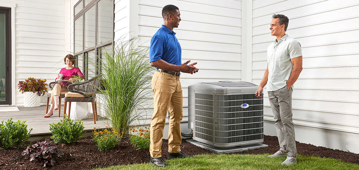 a carrier dealer discusses ac tune up cost with homeowners