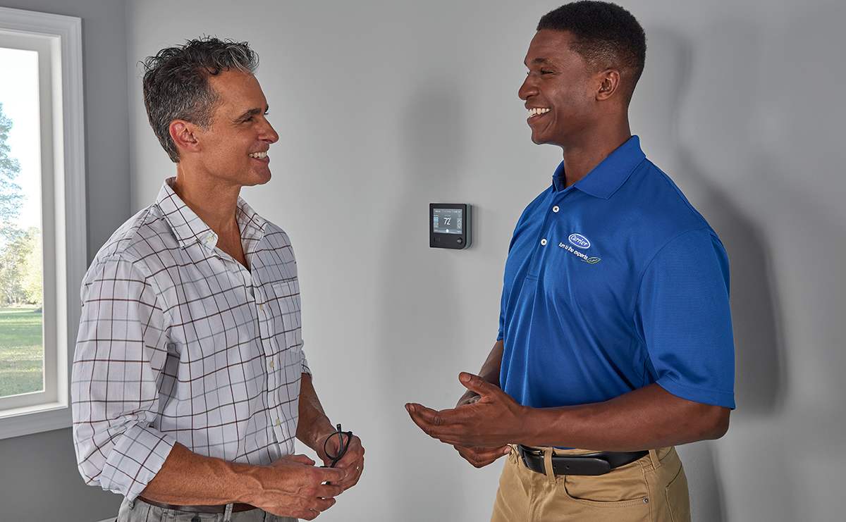 a homeowner discusses furnace lifespan with a carrier dealer