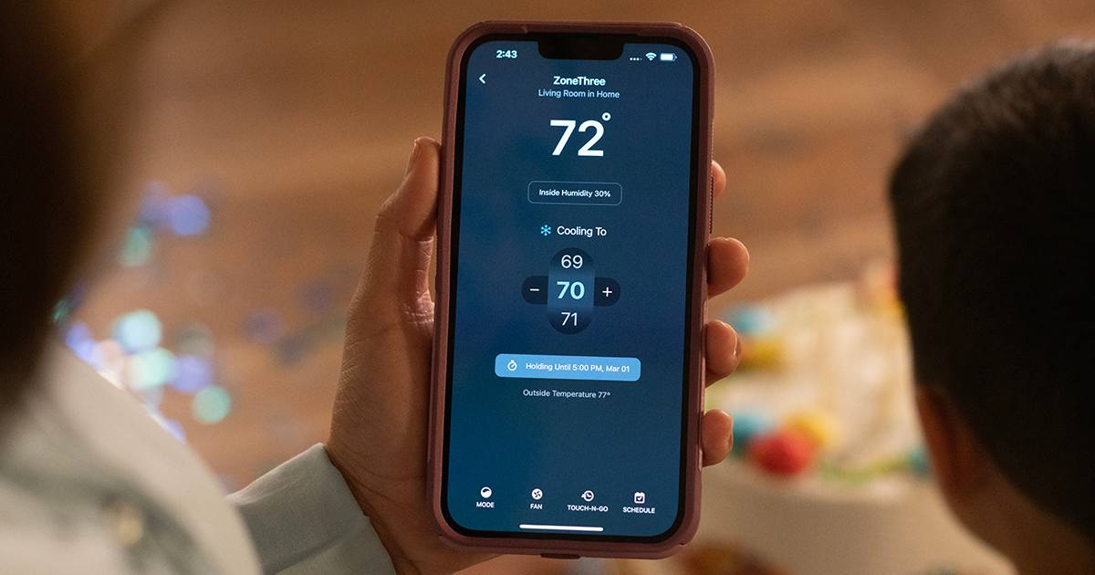 woman using best smart thermostat advantage by adjusting home comfort from her phone