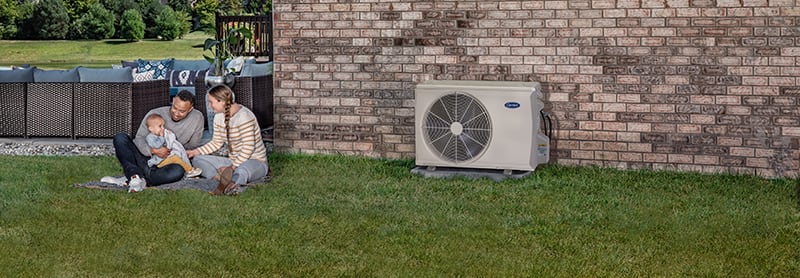 a family plays outside next to a ductless ac