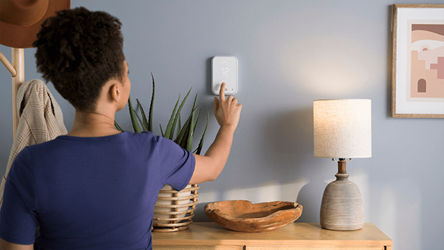 a woman checks if a thermostat setting is why she has an ac not cooling house