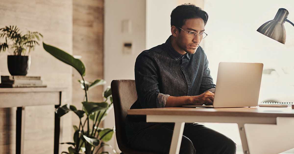 man sitting at a desk on a computer researching oil furnace options