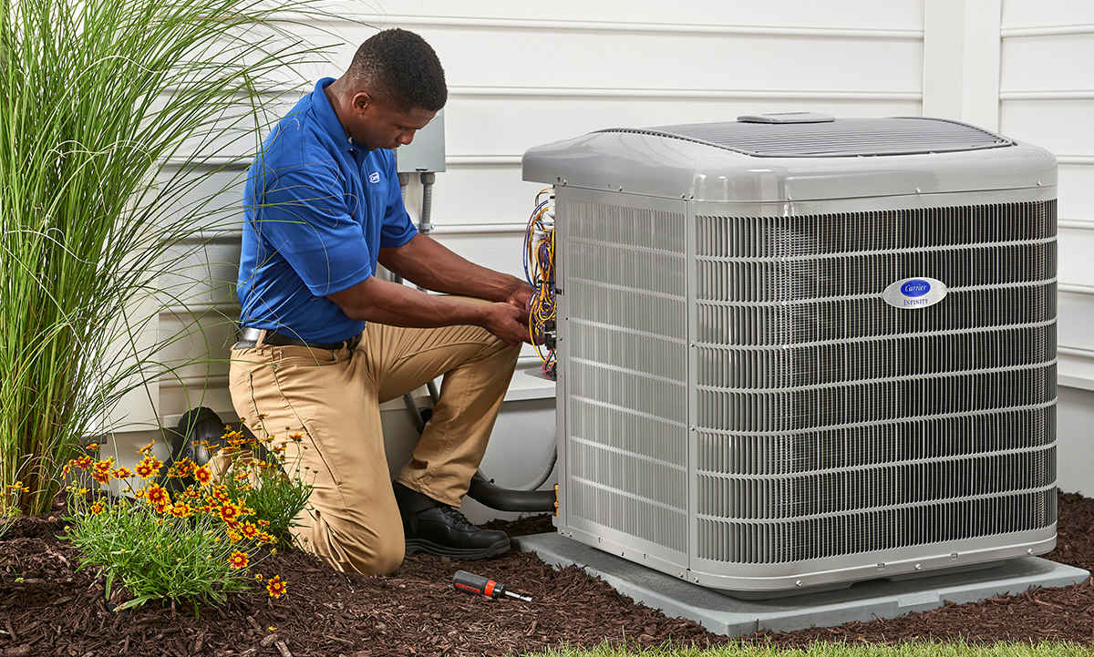 a technician from carrier ac company inspects an air conditioning unit