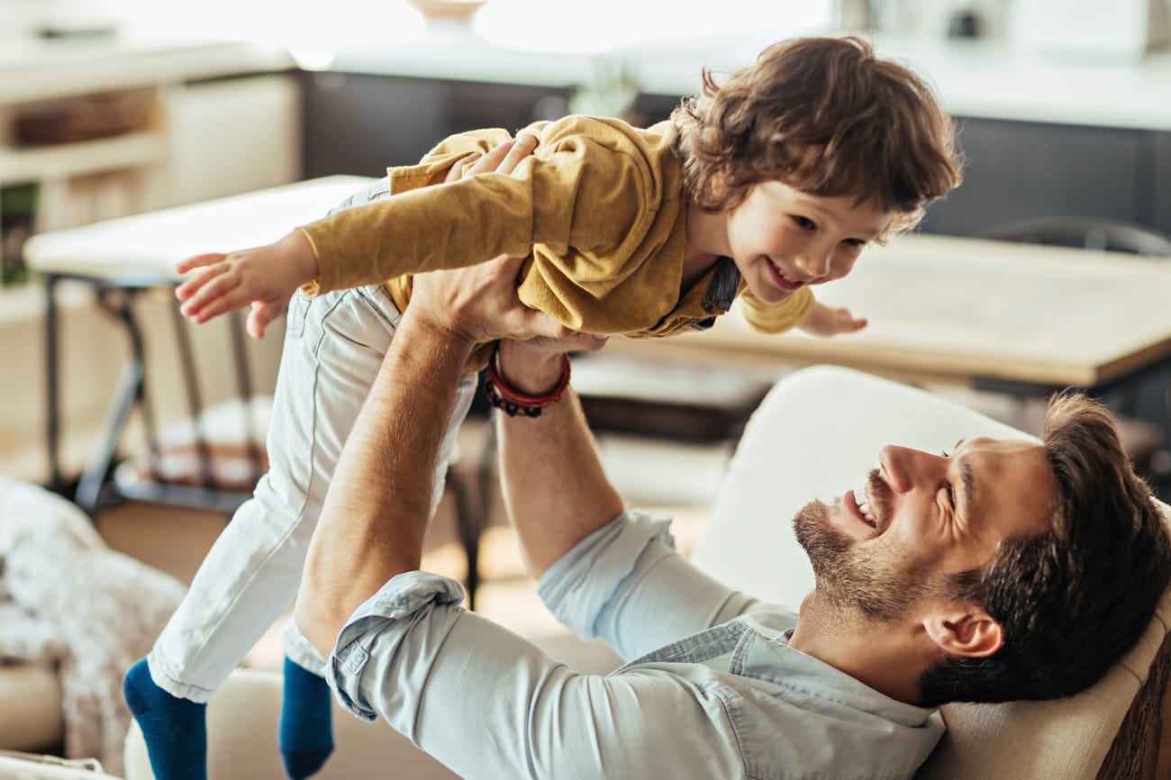 man-lifting-boy-sitting-on-couch