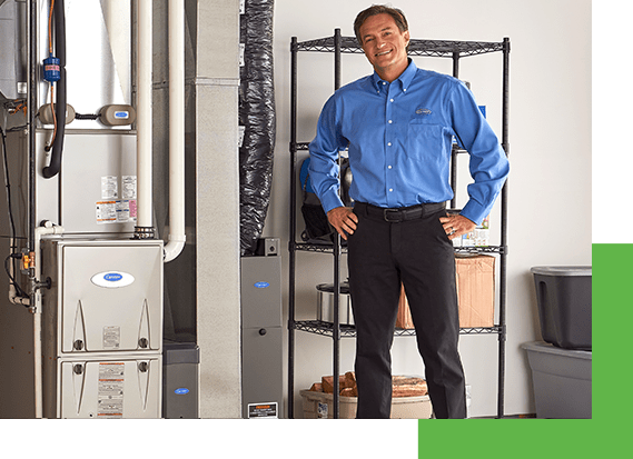 a carrier contractor stands by the furnace in a basement