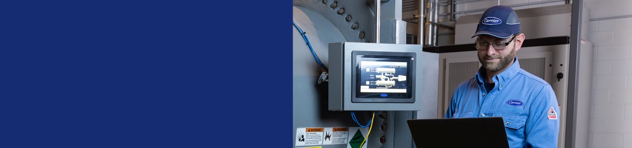service-tech-on-laptop-in-front-of-chiller