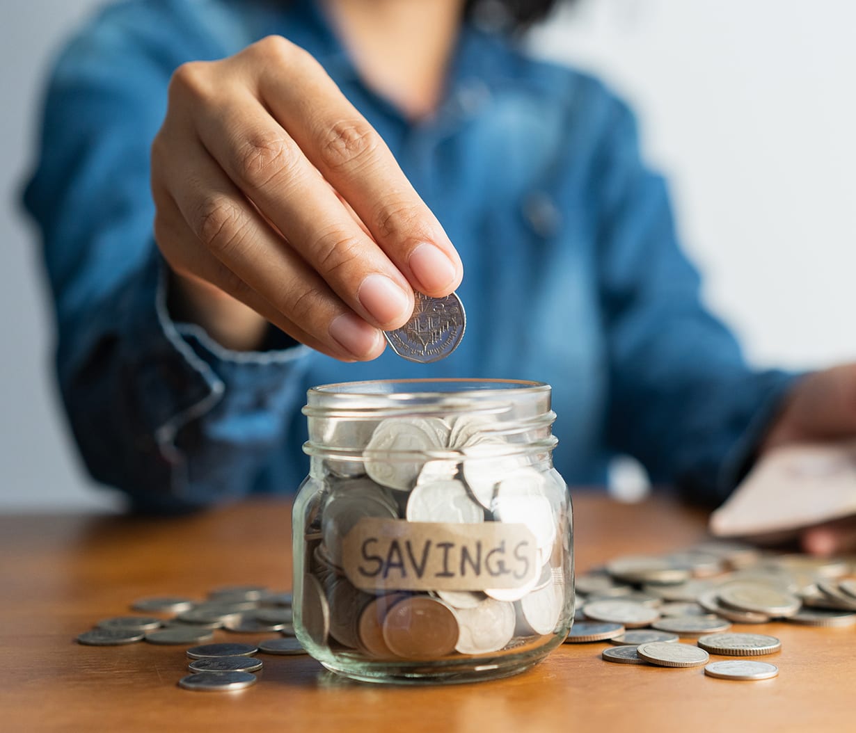 woman-puts-coins-in-savings-jar