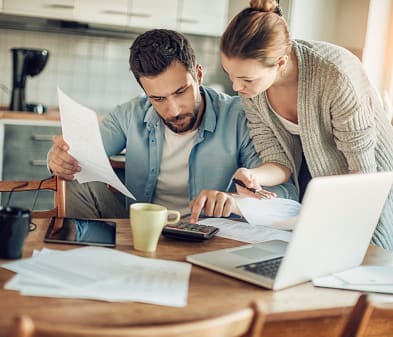 man and woman research heating and air conditioning at kitchen table