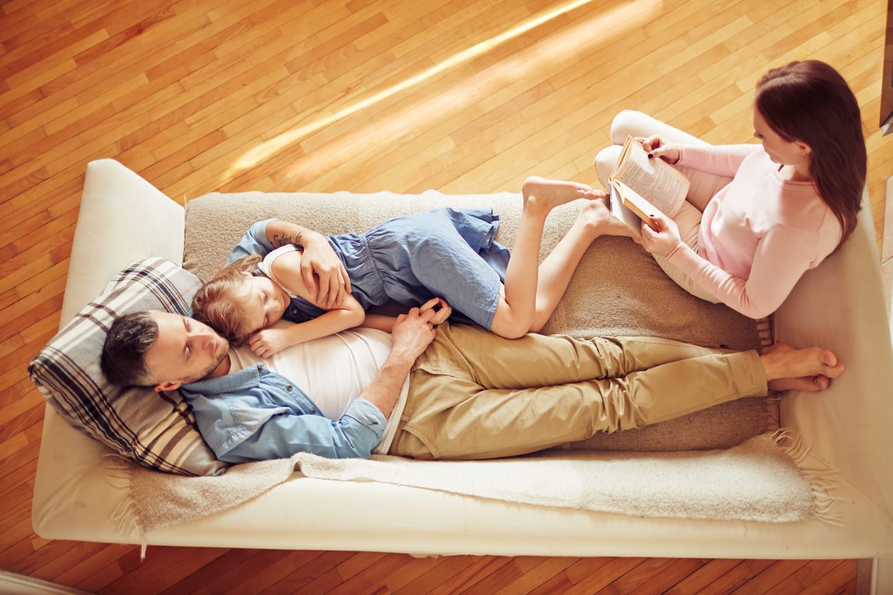 family-relaxing-couch-mother-father-daughter