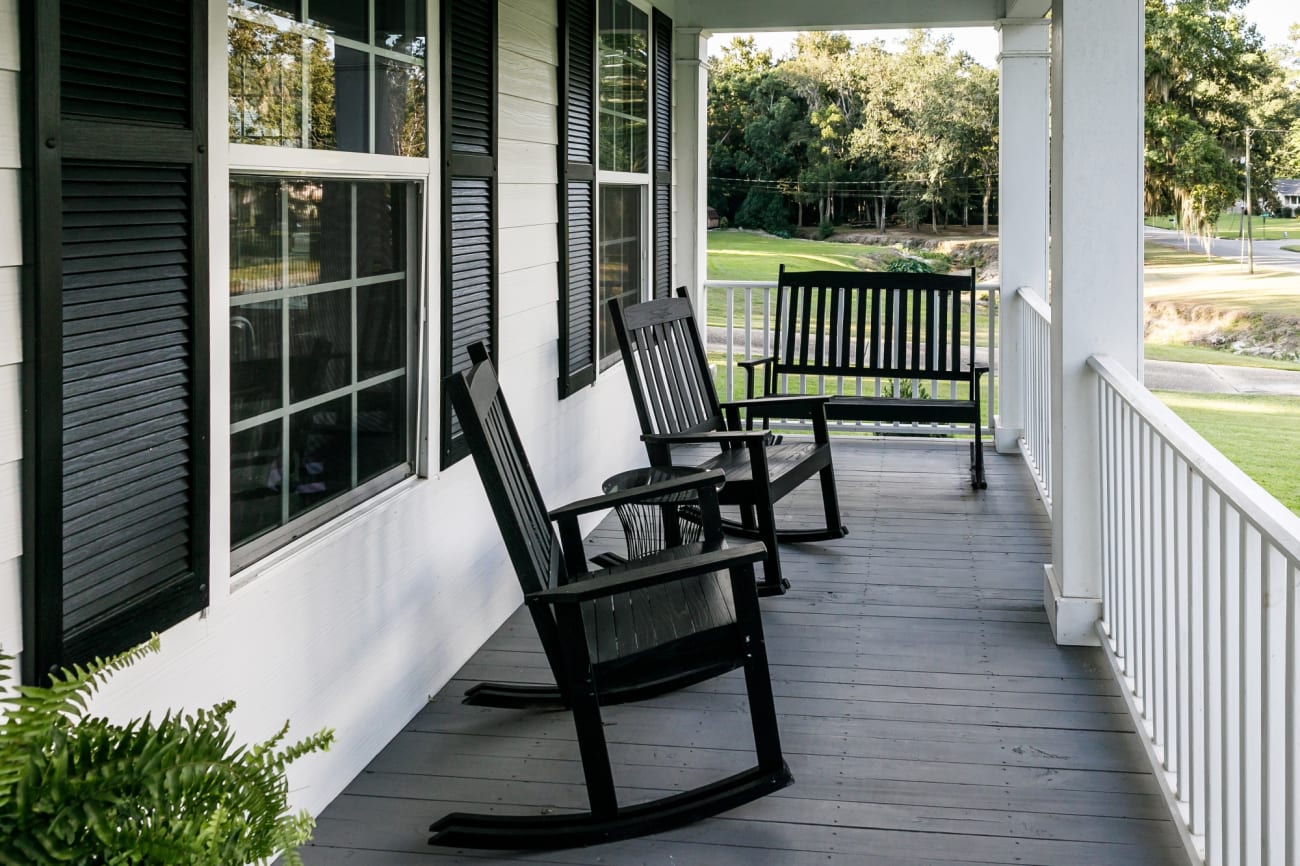 Side view of front porch with rocking chairs and bench