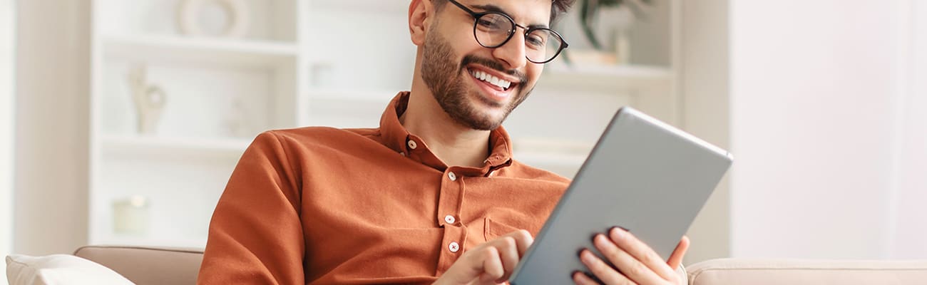 man-on-couch-with-tablet-2000x400