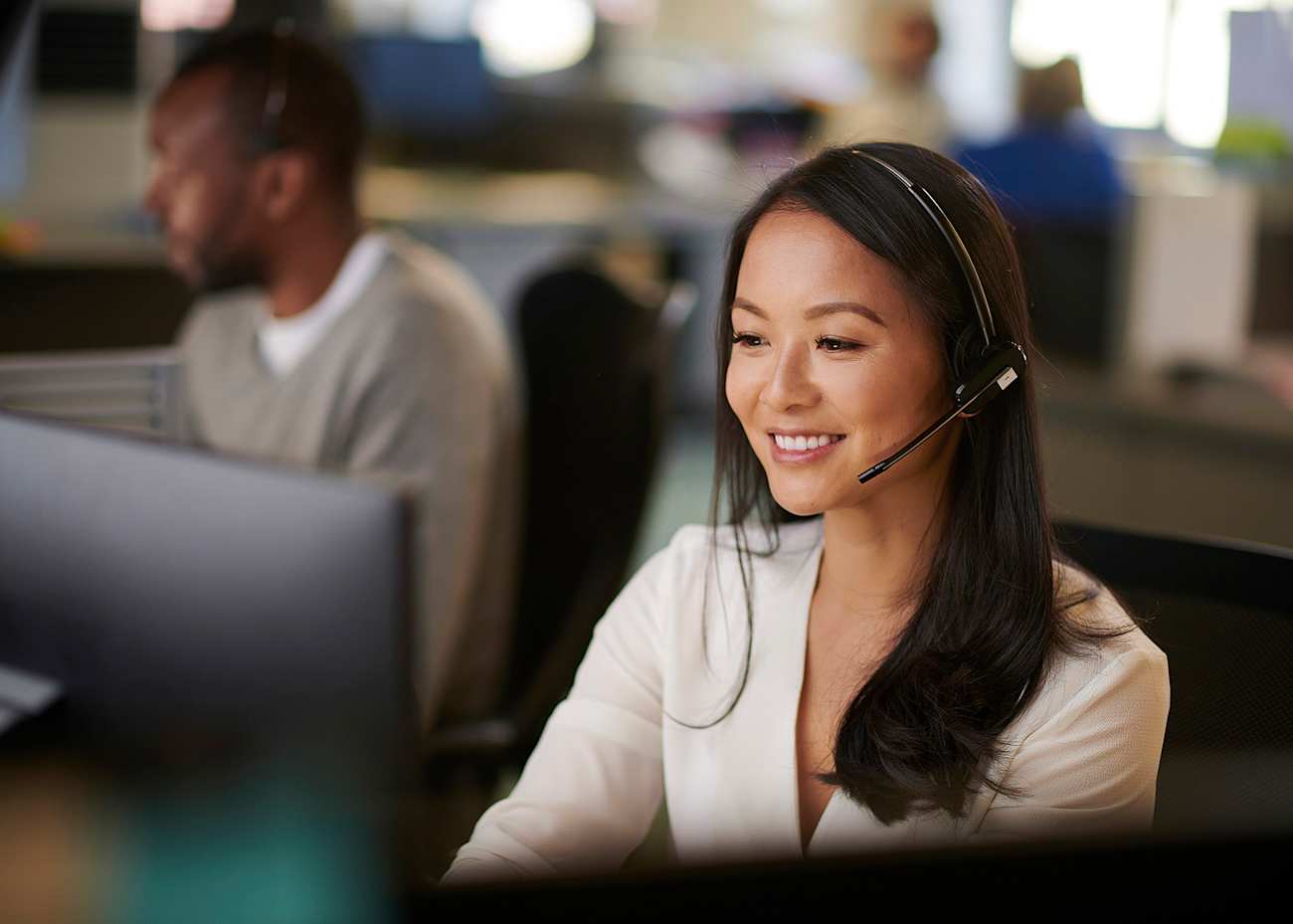 female-customer-service-agent-typing-on-her-computer-and-talking-on-the-phone