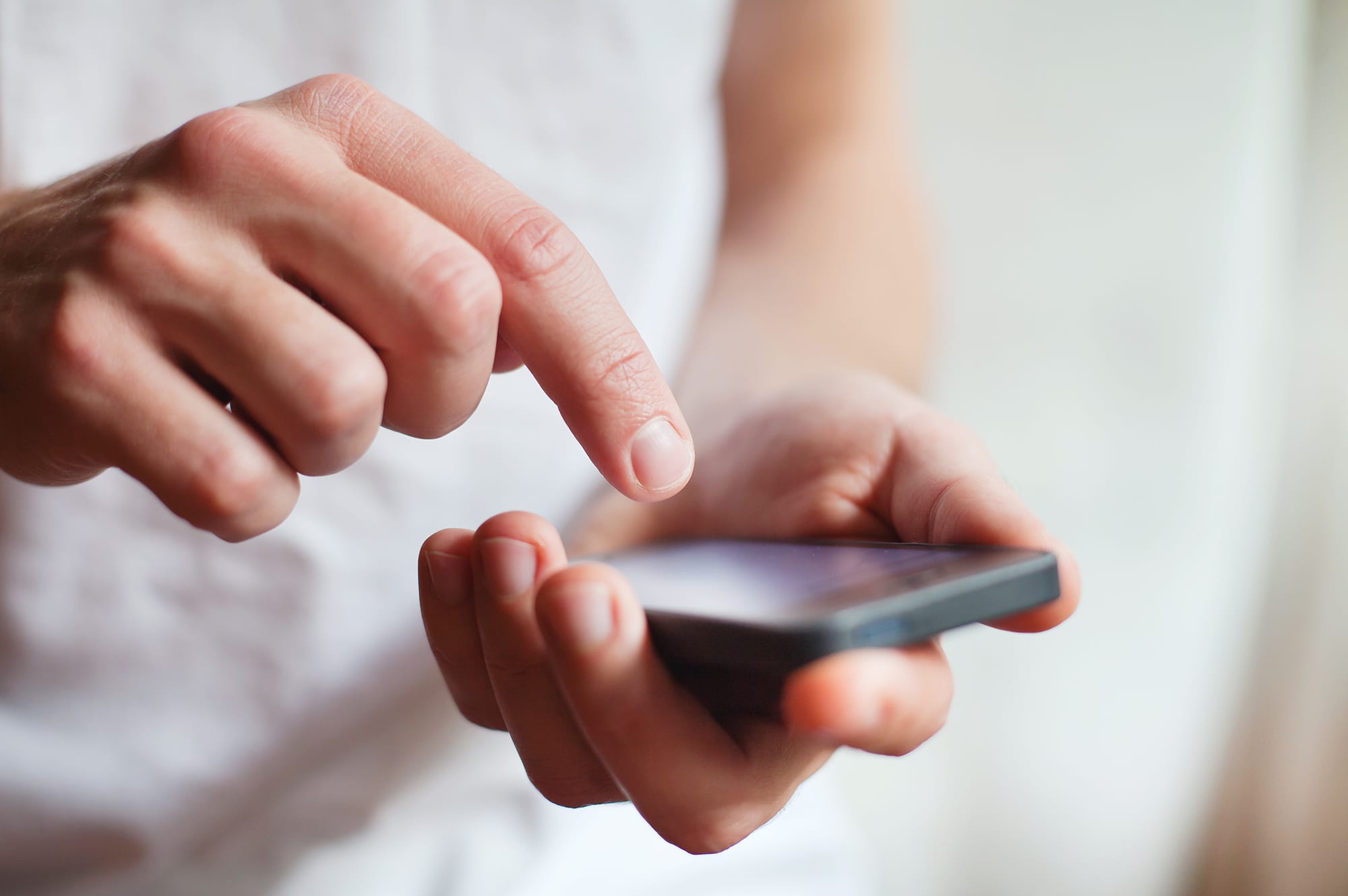 man-tapping-cell-phone