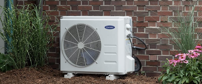 a ductless heat pump sits outside of a home