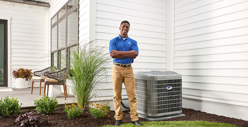 carrier dealer poses next to 2.5 ton ac unit