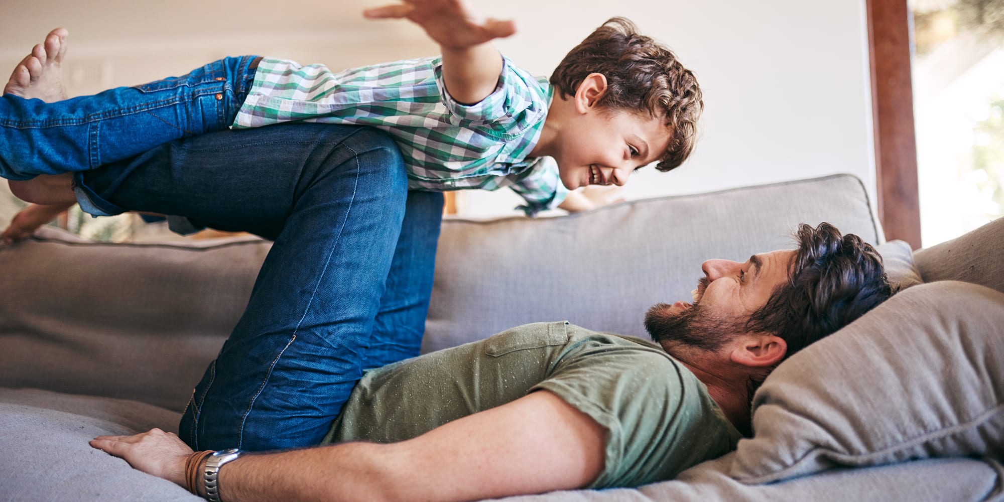 father-and-son-on-couch-playful