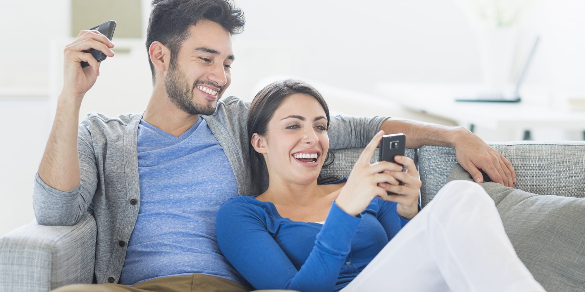 man-and-woman-on-couch-looking-at-phone-3x2