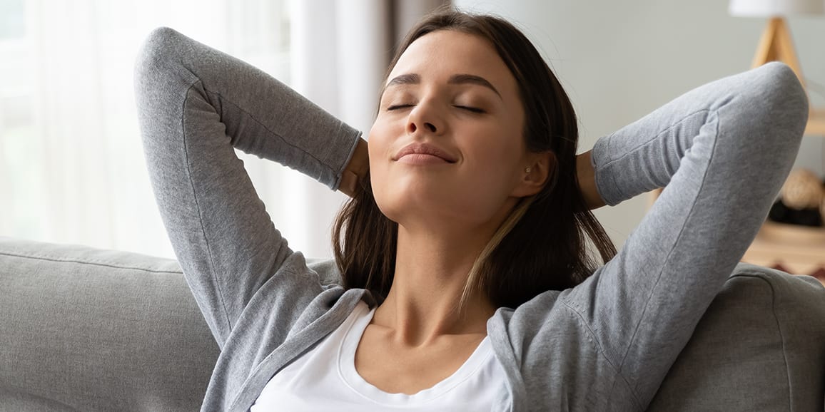 woman-relaxing-couch-arms-behind-head-3x2