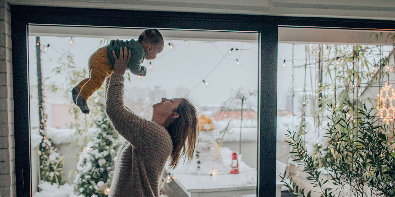 mom-and-baby-in-arms-in-front-of-window-3x2