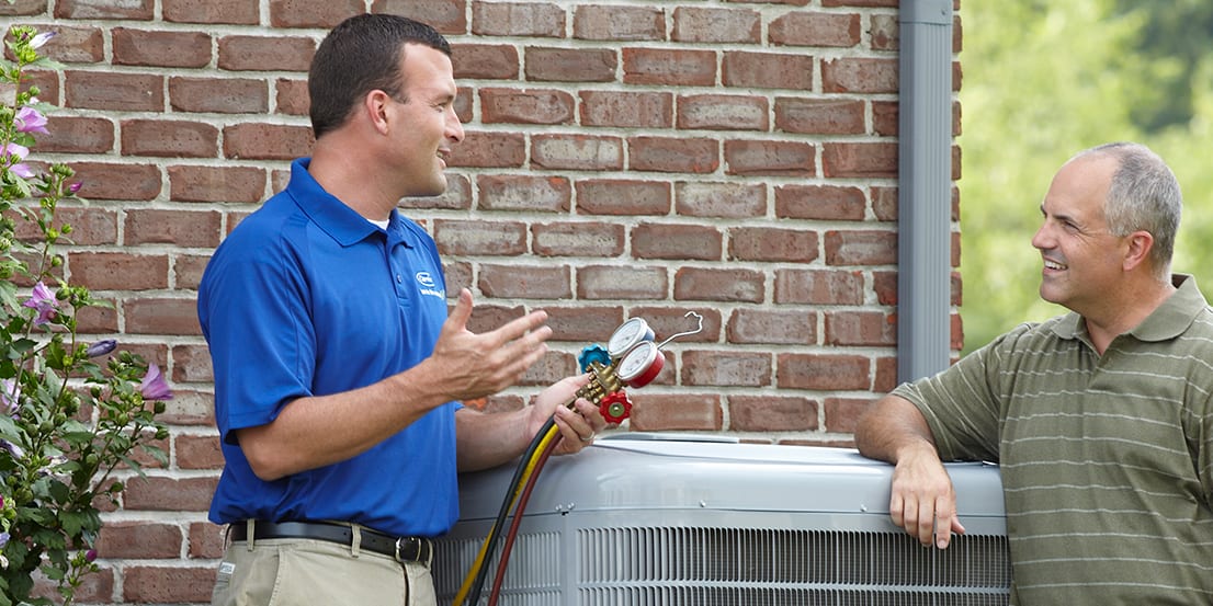 dealer-and-man-standing-next-to-heat-pump-3x2