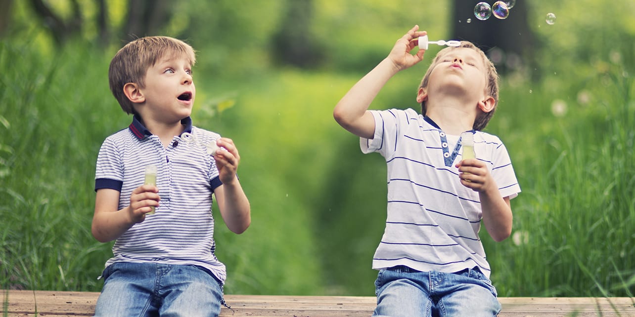 two-boys-blowing-bubbles-nature-3x2
